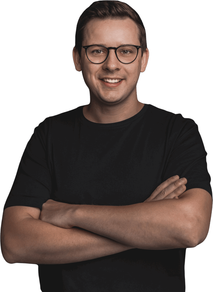 Web-Designer Brian Ossowski steht mit verschränkten Armen und lächelt. Er trägt ein schwarzes T-Shirt. Der Hintergrund ist transparent.